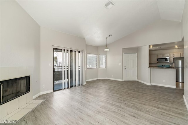 5038 S Rainbow Blvd Unit 206, Las Vegas, NV 89118 - unfurnished living room with a fireplace, vaulted ceiling, and wood finished floors