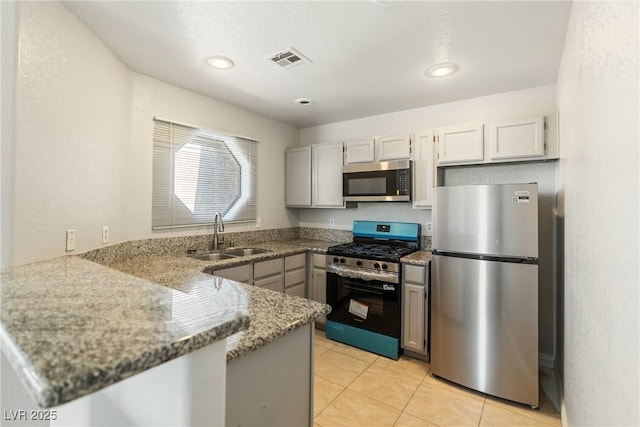 5038 S Rainbow Blvd Unit 206, Las Vegas, NV 89118 - kitchen with appliances with stainless steel finishes, a peninsula, light stone countertops, light tile patterned floors, and recessed lighting