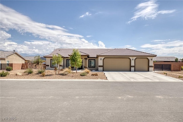 171 Weeping Willow Ct, Pahrump, NV 89048 - mediterranean / spanish house featuring an attached garage, stucco siding, a tiled roof, and concrete driveway