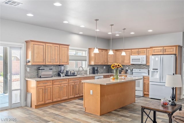 171 Weeping Willow Ct, Pahrump, NV 89048 - kitchen with white appliances, decorative backsplash, a kitchen island, light wood-style flooring, and recessed lighting