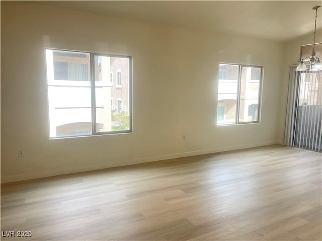 8985 S Durango Dr Unit 2043, Las Vegas, NV 89113 - spare room with a chandelier, healthy amount of natural light, and light wood-type flooring