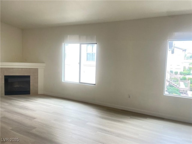 8985 S Durango Dr Unit 2043, Las Vegas, NV 89113 - unfurnished living room featuring light wood-style floors and a tile fireplace