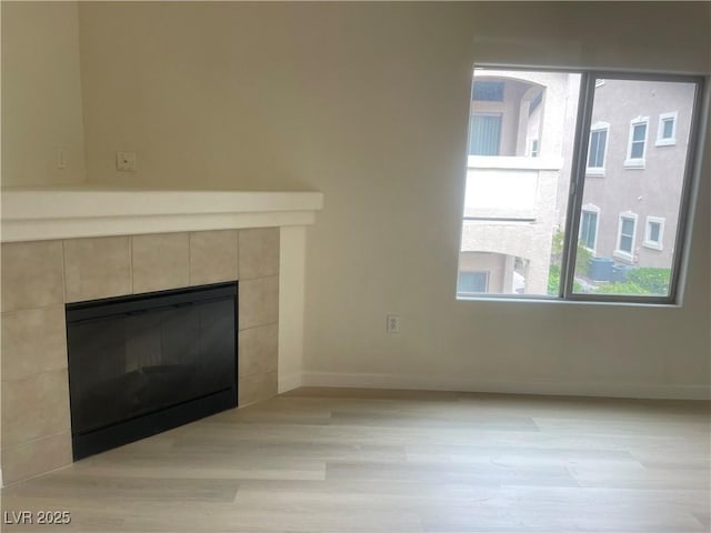 8985 S Durango Dr Unit 2043, Las Vegas, NV 89113 - unfurnished living room featuring light wood-style floors and a tiled fireplace