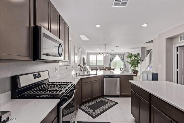 6909 Toll Mountain St, North Las Vegas, NV 89086 - kitchen with stainless steel appliances, light countertops, dark brown cabinets, and recessed lighting