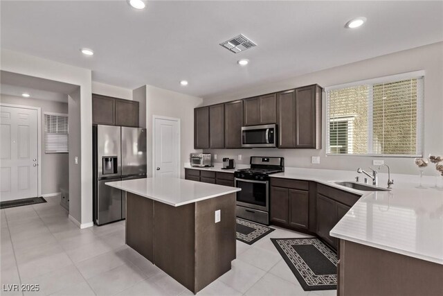 6909 Toll Mountain St, North Las Vegas, NV 89086 - kitchen with stainless steel appliances, dark brown cabinets, light countertops, a kitchen island, and recessed lighting