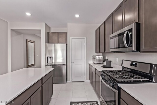 6909 Toll Mountain St, North Las Vegas, NV 89086 - kitchen featuring appliances with stainless steel finishes, light countertops, dark brown cabinets, light tile patterned floors, and recessed lighting