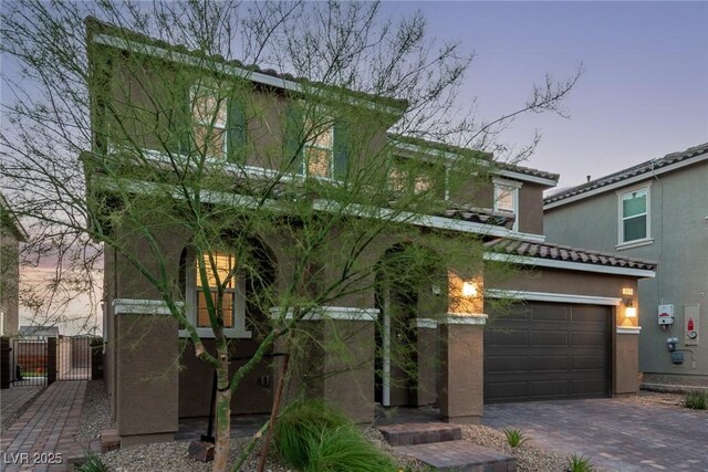6909 Toll Mountain St, North Las Vegas, NV 89086 - view of front of property with a gate, stucco siding, driveway, a tile roof, and an attached garage