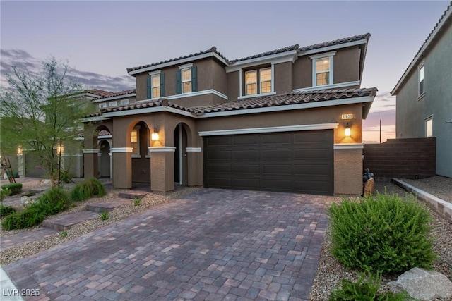 6909 Toll Mountain St, North Las Vegas, NV 89086 - mediterranean / spanish-style house featuring stucco siding, decorative driveway, an attached garage, and a tiled roof