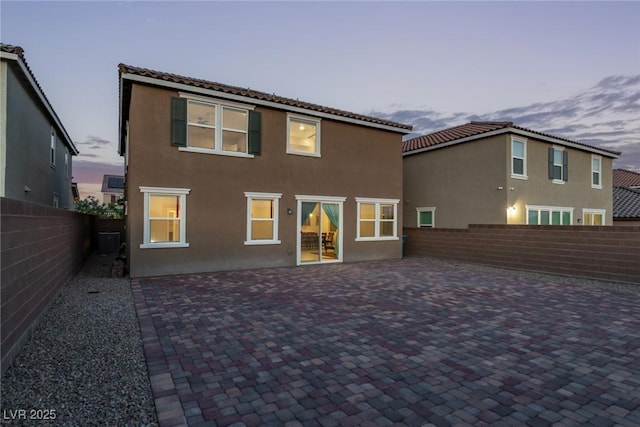 6909 Toll Mountain St, North Las Vegas, NV 89086 - back of house at dusk featuring a fenced backyard, stucco siding, and a patio area