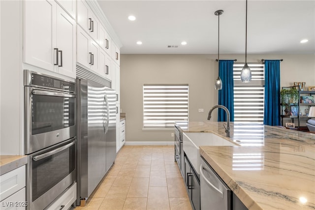 286 Bowsprit Ct, Las Vegas, NV 89183 - kitchen with stainless steel appliances, light stone countertops, white cabinetry, recessed lighting, and hanging light fixtures