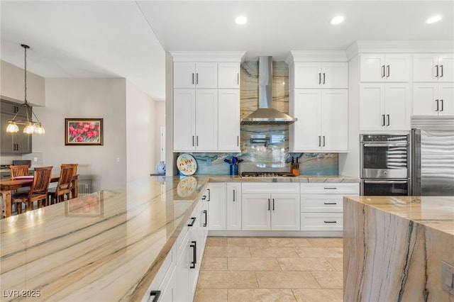286 Bowsprit Ct, Las Vegas, NV 89183 - kitchen featuring wall chimney exhaust hood, appliances with stainless steel finishes, decorative backsplash, pendant lighting, and white cabinets
