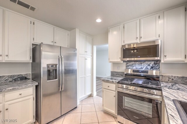 2501 Muirfield Ave, Henderson, NV 89074 - kitchen with appliances with stainless steel finishes, white cabinets, recessed lighting, light tile patterned floors, and light stone countertops