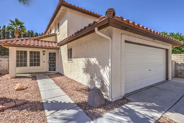 2501 Muirfield Ave, Henderson, NV 89074 - view of property exterior with a garage, driveway, stucco siding, and a tile roof