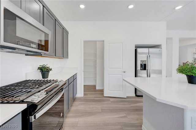 629 Soaring Wings Ave, Las Vegas, NV 89183 - kitchen featuring appliances with stainless steel finishes, light countertops, recessed lighting, gray cabinets, and light wood finished floors