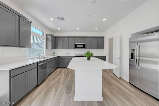 629 Soaring Wings Ave, Las Vegas, NV 89183 - kitchen featuring appliances with stainless steel finishes, a center island, gray cabinetry, light countertops, and light wood-style flooring
