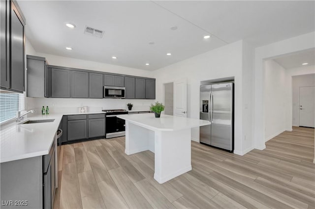 629 Soaring Wings Ave, Las Vegas, NV 89183 - kitchen with stainless steel appliances, light countertops, a center island, light wood-style floors, and recessed lighting