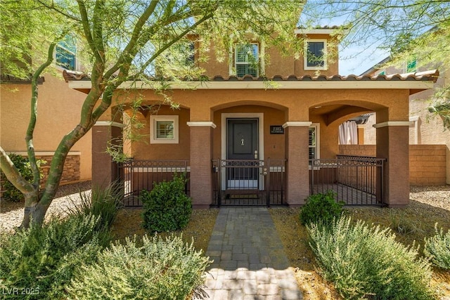 2385 Via Firenze, Henderson, NV 89044 - view of front of house featuring stucco siding, covered porch, a gate, and a tiled roof