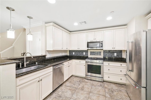 2385 Via Firenze, Henderson, NV 89044 - kitchen with appliances with stainless steel finishes, backsplash, dark stone countertops, decorative light fixtures, and white cabinetry