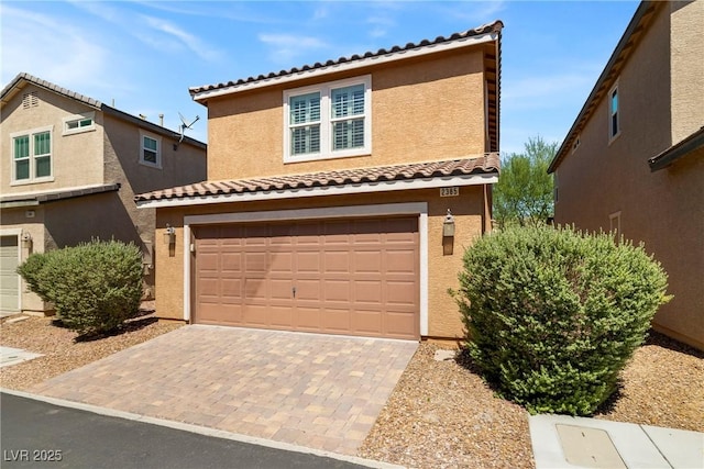 2385 Via Firenze, Henderson, NV 89044 - view of front of house with an attached garage, a tiled roof, stucco siding, and decorative driveway