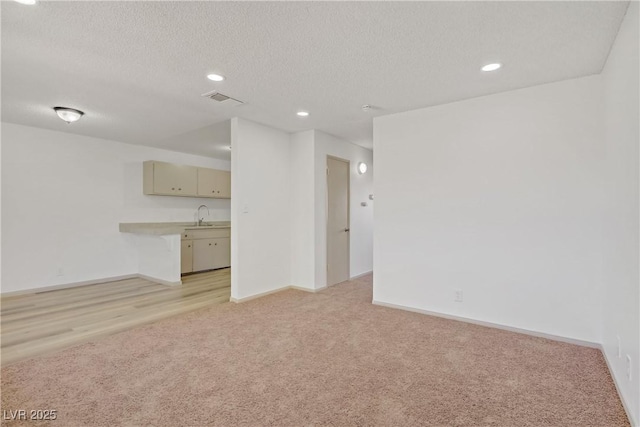304 Orland St Unit 47, Las Vegas, NV 89107 - unfurnished living room with light carpet, recessed lighting, and a textured ceiling