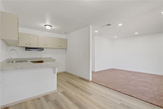 304 Orland St Unit 47, Las Vegas, NV 89107 - kitchen featuring cream cabinets, light countertops, light wood-style floors, a textured ceiling, and recessed lighting