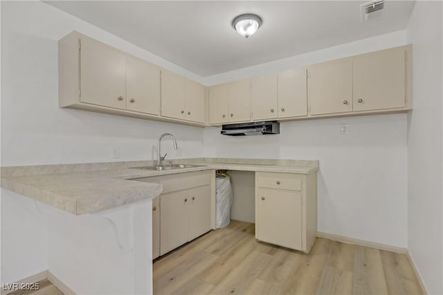 304 Orland St Unit 47, Las Vegas, NV 89107 - kitchen featuring light countertops, light wood-type flooring, a peninsula, and cream cabinets
