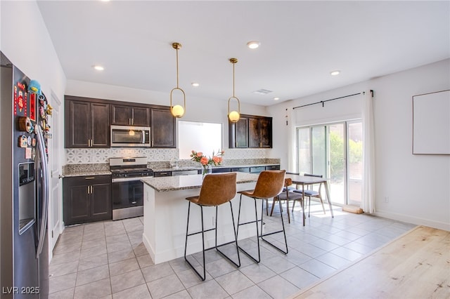10434 Rose Palisade St, Las Vegas, NV 89141 - kitchen featuring stainless steel appliances, backsplash, dark brown cabinetry, a kitchen breakfast bar, and recessed lighting