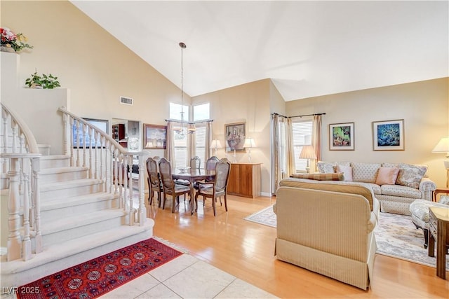 8416 Dry Cliff Cir, Las Vegas, NV 89128 - living area featuring a chandelier, high vaulted ceiling, stairway, and light wood-style floors