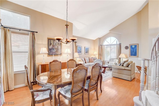 8416 Dry Cliff Cir, Las Vegas, NV 89128 - dining space with light wood-style flooring, a chandelier, high vaulted ceiling, and stairway