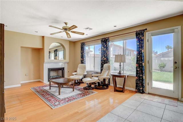 8416 Dry Cliff Cir, Las Vegas, NV 89128 - living area with a tile fireplace, wood finished floors, ceiling fan, and a textured ceiling