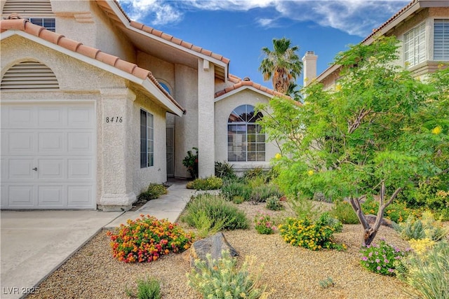 8416 Dry Cliff Cir, Las Vegas, NV 89128 - entrance to property with a garage, stucco siding, and a tile roof