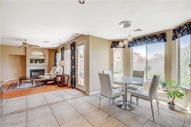 8416 Dry Cliff Cir, Las Vegas, NV 89128 - dining area with plenty of natural light, a glass covered fireplace, light tile patterned floors, and a ceiling fan