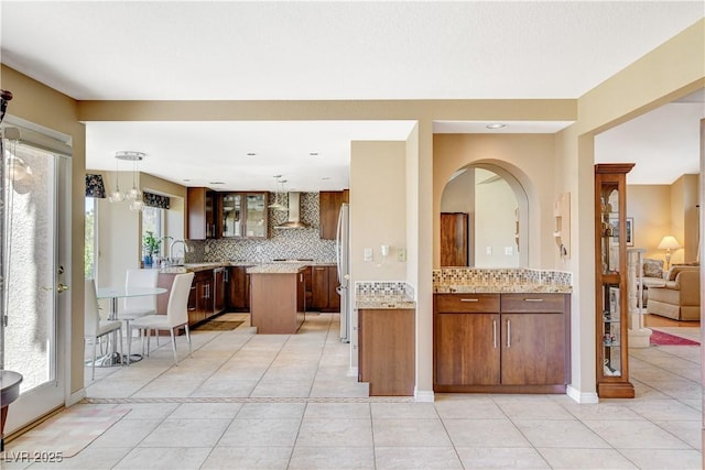 8416 Dry Cliff Cir, Las Vegas, NV 89128 - kitchen with freestanding refrigerator, tasteful backsplash, wall chimney range hood, and healthy amount of natural light