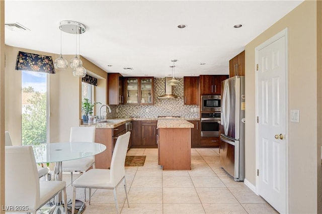 8416 Dry Cliff Cir, Las Vegas, NV 89128 - kitchen featuring appliances with stainless steel finishes, wall chimney range hood, a center island, tasteful backsplash, and glass insert cabinets