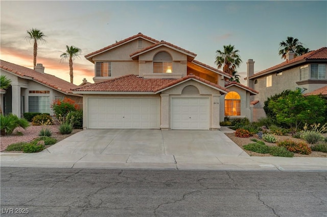 8416 Dry Cliff Cir, Las Vegas, NV 89128 - view of front facade featuring stucco siding, driveway, a tiled roof, and an attached garage