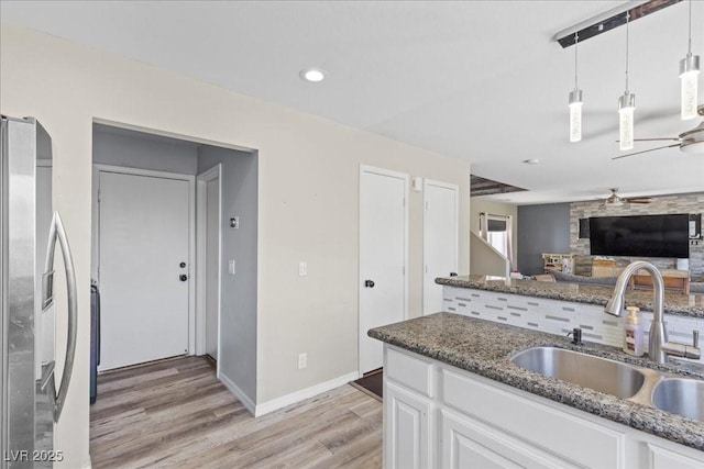 3871 Trellis View Ave, Las Vegas, NV 89115 - kitchen featuring freestanding refrigerator, a ceiling fan, light wood-type flooring, white cabinets, and dark stone counters