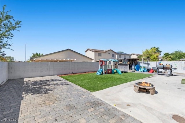 3871 Trellis View Ave, Las Vegas, NV 89115 - fenced backyard with a fire pit, a playground, and a patio area