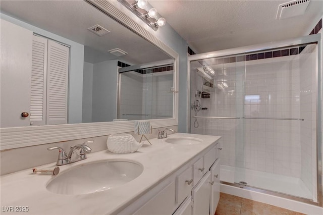 4742 Obannon Dr Unit A, Las Vegas, NV 89102 - bathroom with a shower stall, double vanity, tile patterned flooring, and a textured ceiling