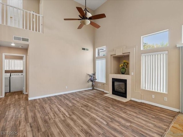7924 Mcdowell Dr, Las Vegas, NV 89129 - unfurnished living room featuring separate washer and dryer, a ceiling fan, high vaulted ceiling, wood finished floors, and plenty of natural light