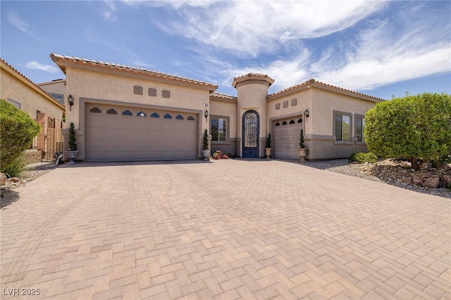 1329 Calle Cantar, Henderson, NV 89012 - mediterranean / spanish home with a garage, decorative driveway, stucco siding, and a tiled roof