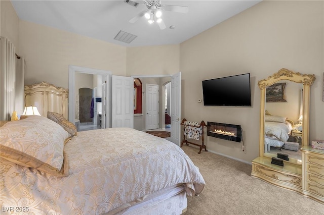 1329 Calle Cantar, Henderson, NV 89012 - bedroom with light colored carpet, a glass covered fireplace, ceiling fan, and ensuite bath