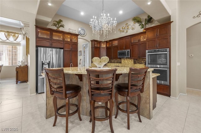 1329 Calle Cantar, Henderson, NV 89012 - kitchen featuring stainless steel appliances, backsplash, arched walkways, light tile patterned floors, and recessed lighting