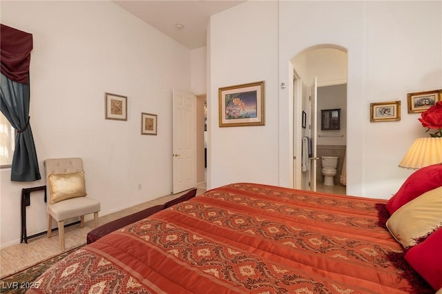 1329 Calle Cantar, Henderson, NV 89012 - bedroom featuring arched walkways, connected bathroom, and a towering ceiling