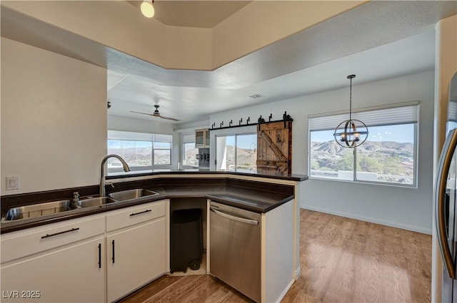 483 Marina Cv, Boulder City, NV 89005 - kitchen with dishwasher, dark countertops, light wood-style flooring, white cabinetry, and a chandelier
