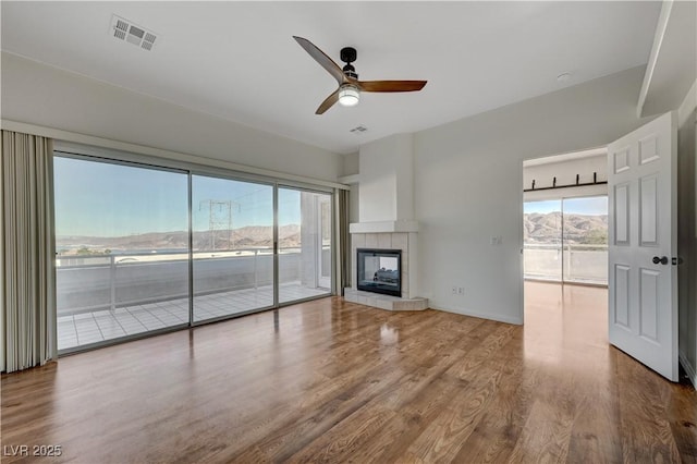 483 Marina Cv, Boulder City, NV 89005 - unfurnished living room with a ceiling fan, wood finished floors, and a tiled fireplace
