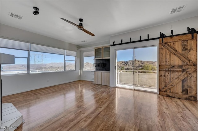 483 Marina Cv, Boulder City, NV 89005 - unfurnished living room with a barn door, ceiling fan, and wood finished floors
