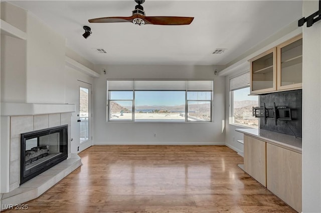 483 Marina Cv, Boulder City, NV 89005 - unfurnished living room featuring ceiling fan, a tile fireplace, and light wood-style floors