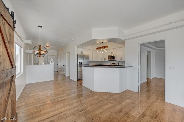 483 Marina Cv, Boulder City, NV 89005 - kitchen featuring a chandelier, stainless steel appliances, dark countertops, white cabinetry, and light wood-type flooring