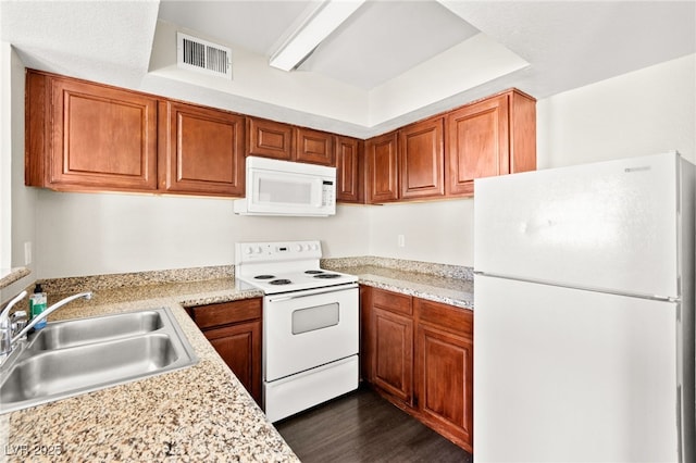 6800 E Lake Mead Blvd Unit 1018, Las Vegas, NV 89156 - kitchen with white appliances, light countertops, brown cabinetry, and dark wood finished floors