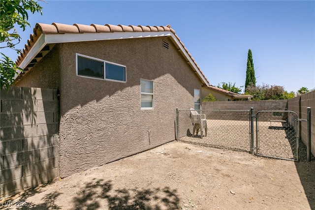 4825 White Aspen Ave, Las Vegas, NV 89130 - view of property exterior with a gate, stucco siding, and a tiled roof